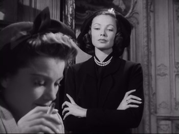Movie still from “The Razor's Edge” (1946), directed by Edmund Goulding – A woman standing next to another woman in front of a mirror; Medium shot, Low angle