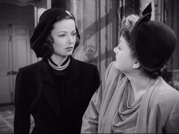 Movie still from “The Razor's Edge” (1946), directed by Edmund Goulding – Two women wearing hats and one of them is wearing pearls; Close Up shot, Over the shoulder angle