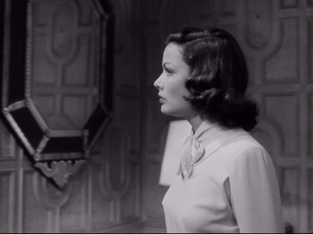 Movie still from “The Razor's Edge” (1946), directed by Edmund Goulding – A black - and - white photo of a woman looking at her reflection in a mirror; Medium shot, Over the shoulder angle