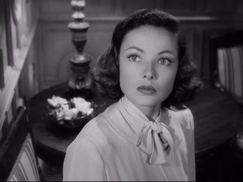 Movie still from “The Razor's Edge” (1946), directed by Edmund Goulding – A black - and - white photo of a woman in front of a table; Close Up shot, Low angle