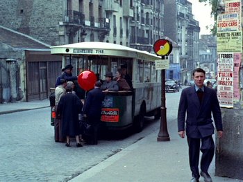 Movie still from “The Red Balloon” (1956), directed by Albert Lamorisse – A group of people standing on the side of a street; Wide shot, High angle