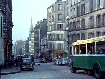 Movie still from “The Red Balloon” (1956), directed by Albert Lamorisse – A street scene with cars and a trolley; Extreme Wide shot, High angle