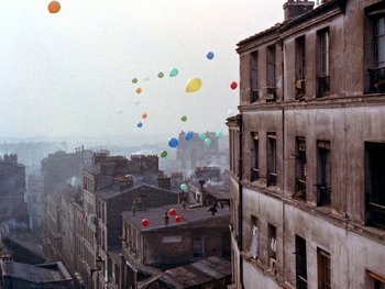 Movie still from “The Red Balloon” (1956), directed by Albert Lamorisse – A bunch of balloons flying in the air over a city; Extreme Wide shot, High angle
