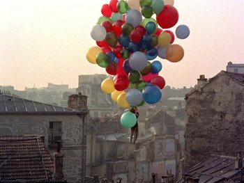 Movie still from “The Red Balloon” (1956), directed by Albert Lamorisse – A bunch of balloons floating in the air over a city; Extreme Wide shot, Low angle