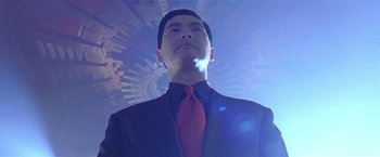 Movie still from “The Replacement Killers” (1998), directed by Antoine Fuqua – A man wearing a suit and red neck tie; Close Up shot, Low angle