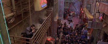 Movie still from “The Replacement Killers” (1998), directed by Antoine Fuqua – A group of people standing around a building with smoke coming out of it; Extreme Wide shot, High angle