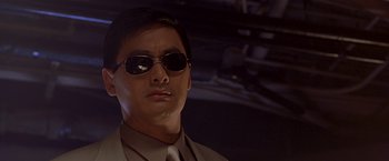 Movie still from “The Replacement Killers” (1998), directed by Antoine Fuqua – A person wearing a suit and sunglasses; Close Up shot, Low angle
