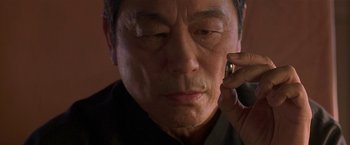 Movie still from “The Replacement Killers” (1998), directed by Antoine Fuqua – An older man talking on a cell phone; Close Up shot, Over the shoulder angle