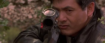 Movie still from “The Replacement Killers” (1998), directed by Antoine Fuqua – A person with a rifle; Close Up shot, Low angle