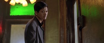 Movie still from “The Replacement Killers” (1998), directed by Antoine Fuqua – A person wearing a suit and tie; Close Up shot, Over the shoulder angle