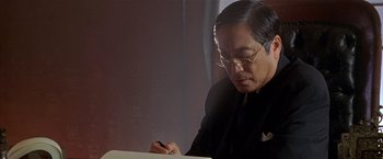 Movie still from “The Replacement Killers” (1998), directed by Antoine Fuqua – An older man writing on a piece of paper; Close Up shot, Low angle