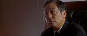 Movie still from “The Replacement Killers” (1998), directed by Antoine Fuqua – An older asian man in a suit and tie; Close Up shot, Low angle