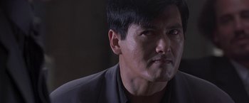 Movie still from “The Replacement Killers” (1998), directed by Antoine Fuqua – A person wearing a suit and tie; Close Up shot, Over the shoulder angle