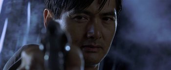 Movie still from “The Replacement Killers” (1998), directed by Antoine Fuqua – A person holding a gun; Close Up shot, Low angle