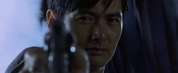 Movie still from “The Replacement Killers” (1998), directed by Antoine Fuqua – A person holding a gun; Close Up shot, Low angle