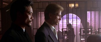 Movie still from “The Replacement Killers” (1998), directed by Antoine Fuqua – A man in a suit and tie standing next to another man in a suit and tie; Close Up shot, Low angle