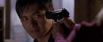 Movie still from “The Replacement Killers” (1998), directed by Antoine Fuqua – A man holding a gun up to his head; Close Up shot, Over the shoulder angle