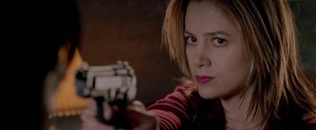 Movie still from “The Replacement Killers” (1998), directed by Antoine Fuqua – A woman is holding a gun in her hand; Close Up shot, Over the shoulder angle