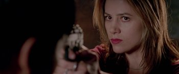 Movie still from “The Replacement Killers” (1998), directed by Antoine Fuqua – A person holding a gun in a dark room; Close Up shot, Over the shoulder angle