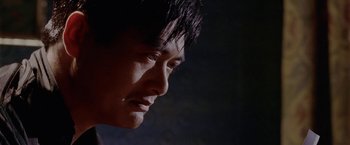 Movie still from “The Replacement Killers” (1998), directed by Antoine Fuqua – A man's face in the dark; Close Up shot, Low angle