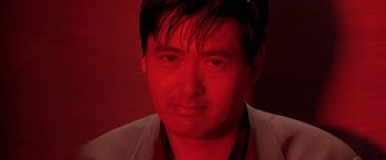 Movie still from “The Replacement Killers” (1998), directed by Antoine Fuqua – A person wearing a suit; Close Up shot, Low angle