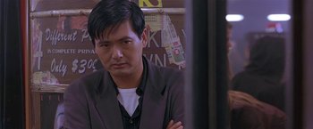 Movie still from “The Replacement Killers” (1998), directed by Antoine Fuqua – A person wearing a suit and tie; Close Up shot, Over the shoulder angle