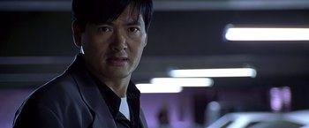 Movie still from “The Replacement Killers” (1998), directed by Antoine Fuqua – A person wearing a suit and tie; Close Up shot, Low angle