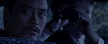 Movie still from “The Replacement Killers” (1998), directed by Antoine Fuqua – A person in a car on a street; Extreme Close Up shot, Over the shoulder angle