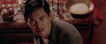 Movie still from “The Replacement Killers” (1998), directed by Antoine Fuqua – A person sitting down in a room; Close Up shot, Low angle