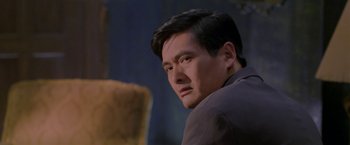 Movie still from “The Replacement Killers” (1998), directed by Antoine Fuqua – A person wearing a suit and tie; Close Up shot, Over the shoulder angle