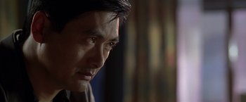 Movie still from “The Replacement Killers” (1998), directed by Antoine Fuqua – A person looking down at his face; Close Up shot, Over the shoulder angle