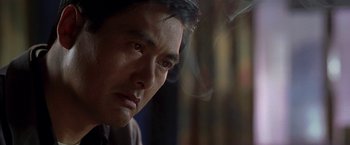 Movie still from “The Replacement Killers” (1998), directed by Antoine Fuqua – A man's face with smoke coming out of his mouth; Close Up shot, Over the shoulder angle