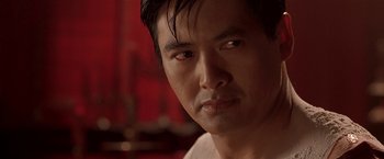 Movie still from “The Replacement Killers” (1998), directed by Antoine Fuqua – A man's face in a red room; Close Up shot, Over the shoulder angle