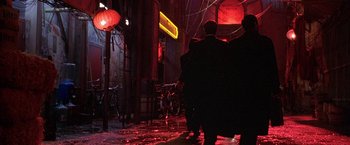 Movie still from “The Replacement Killers” (1998), directed by Antoine Fuqua – A group of people standing on a street at night; Wide shot, Low angle