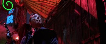 Movie still from “The Replacement Killers” (1998), directed by Antoine Fuqua – A man in a suit and tie looking up at the ceiling; Medium shot, Low angle