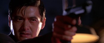 Movie still from “The Replacement Killers” (1998), directed by Antoine Fuqua – A man holding a gun in his hand; Close Up shot, Low angle