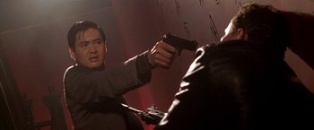 Movie still from “The Replacement Killers” (1998), directed by Antoine Fuqua – A man holding a gun in a room; Close Up shot, Low angle