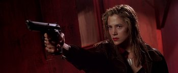 Movie still from “The Replacement Killers” (1998), directed by Antoine Fuqua – A woman is holding a gun in a room; Close Up shot, Low angle