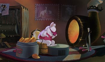 Movie still from “The Rescuers Down Under” (1990), directed by Mike Gabriel – An animated mouse is sitting on a barrel in a room; Wide shot, High angle