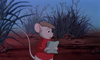 Movie still from “The Rescuers Down Under” (1990), directed by Mike Gabriel – A mouse holding a piece of paper while standing in a field; Medium shot, Over the shoulder angle