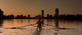 Movie still from “The River Wild” (1994), directed by Curtis Hanson – A person rowing a boat on a large body of water; Extreme Wide shot, High angle