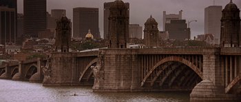 Movie still from “The River Wild” (1994), directed by Curtis Hanson – A view of a bridge and a city skyline from across the river; Extreme Wide shot, High angle