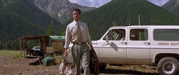 Movie still from “The River Wild” (1994), directed by Curtis Hanson – A man standing in front of a white pickup truck; Wide shot, Low angle