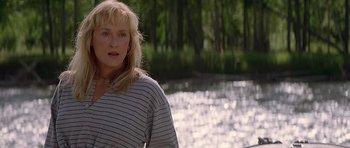 Movie still from “The River Wild” (1994), directed by Curtis Hanson – A woman standing in front of a body of water; Close Up shot, Over the shoulder angle