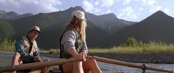 Movie still from “The River Wild” (1994), directed by Curtis Hanson – A woman sitting in a boat on a river; Medium shot, Low angle