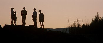 Movie still from “The River Wild” (1994), directed by Curtis Hanson – Two people standing on a hill at sunset; Wide shot, Low angle