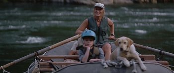 Movie still from “The River Wild” (1994), directed by Curtis Hanson – A woman and a boy are in a boat with a dog; Medium shot, High angle