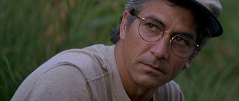 Movie still from “The River Wild” (1994), directed by Curtis Hanson – A person wearing glasses; Close Up shot, Over the shoulder angle