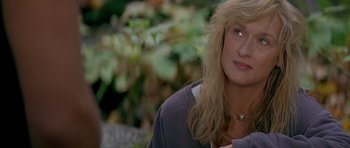 Movie still from “The River Wild” (1994), directed by Curtis Hanson – A woman with long blonde hair is looking to her left; Close Up shot, Over the shoulder angle