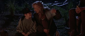 Movie still from “The River Wild” (1994), directed by Curtis Hanson – A woman sitting next to a young boy on the ground; Medium shot, Over the shoulder angle